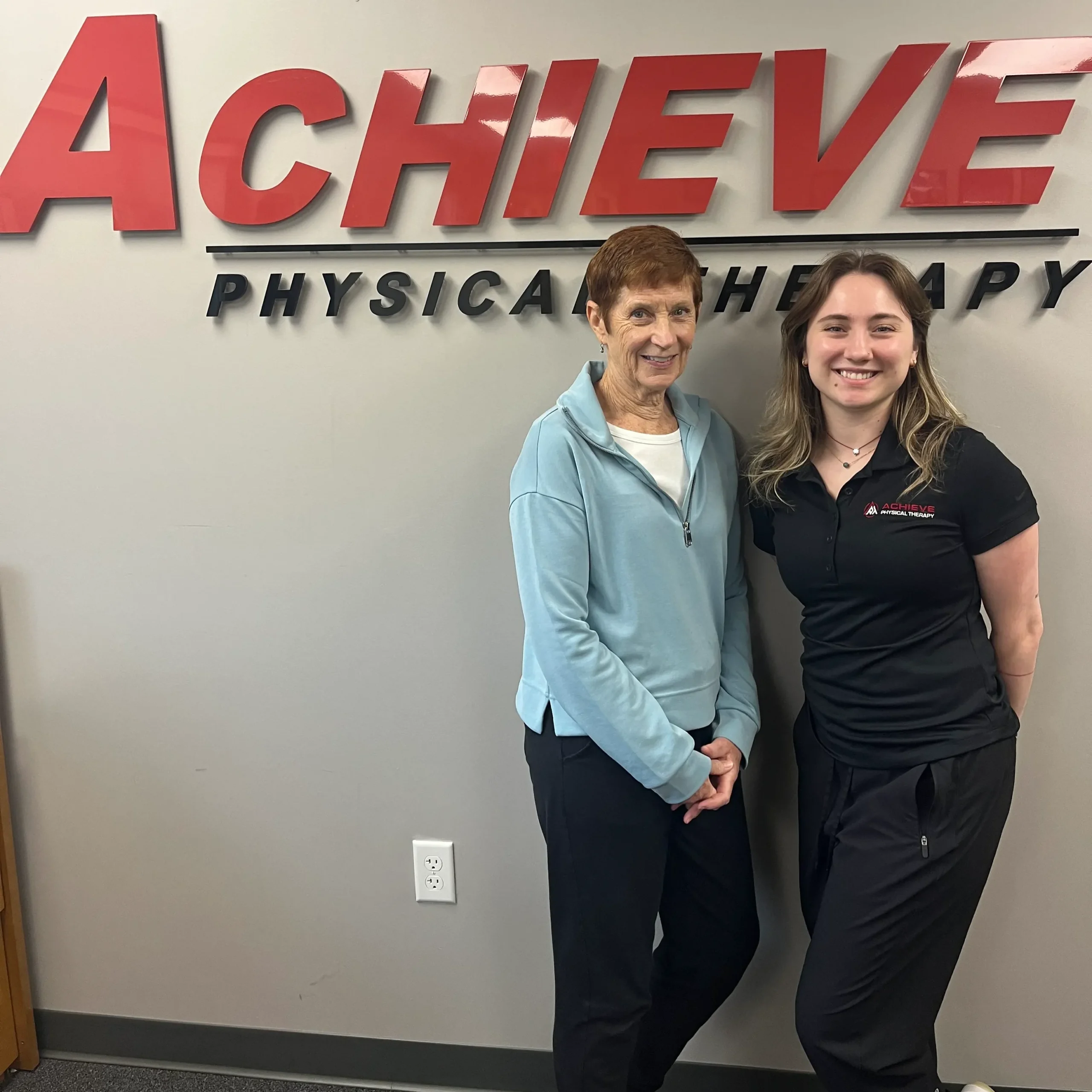 Lisa D and physical therapist Chloe S stand together, smiling after a her successful physical therapy program 