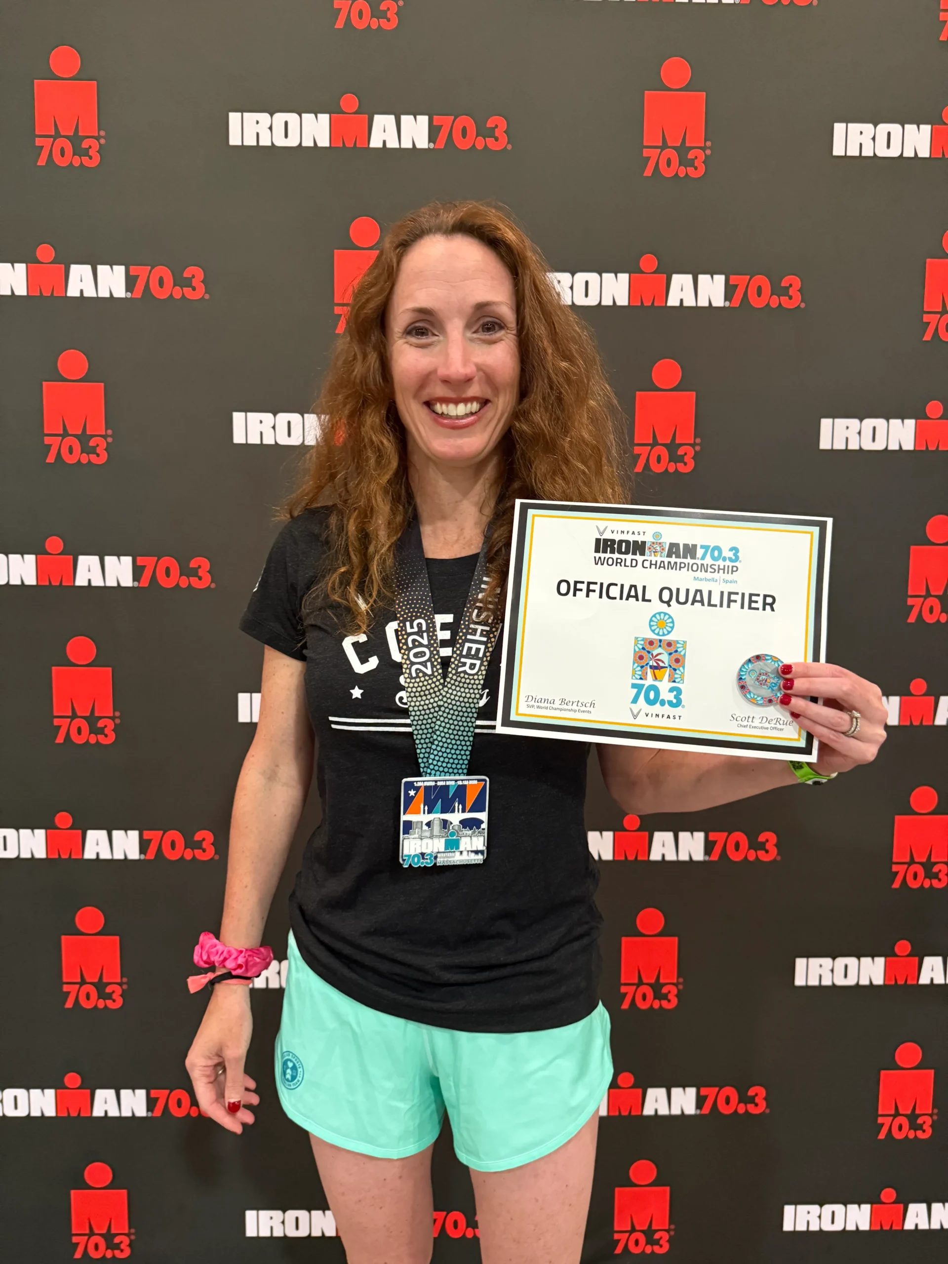 Jennifer F holding up her Ironman Official Qualifier Certificate