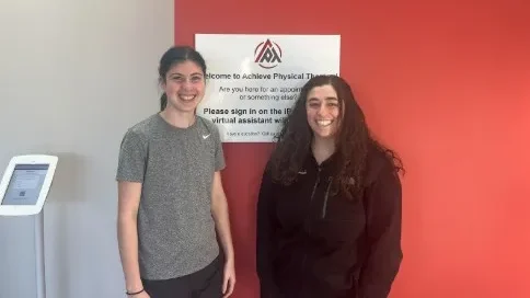 Hannah, a patient of Achieve PT, and Emily B, the physical therapist treating her, smile and pose together