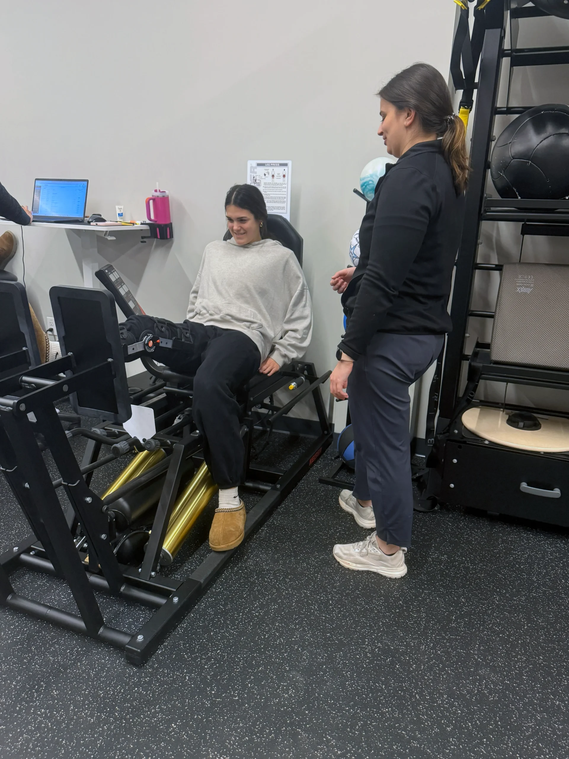 Physical therapist guiding a patient through a leg-strengthening exercise to prepare for upcoming surgery